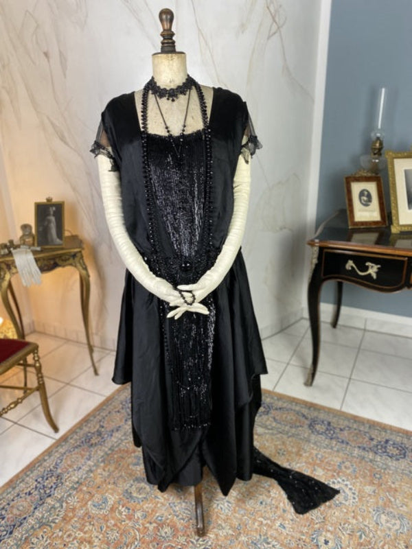 1918 formal dresses 1918. Jacques Doucet evening gown of ivory colored silk satin, ornamented with a double swag of jet beads that start at the shoulder and attaches at the right hip with a large